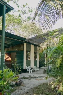 a green house with two chairs and a patio at Chilamate Rainforest Beach Retreat in Nosara
