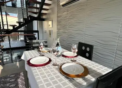a table with two plates and wine glasses on it at Casa Solana in Puntarenas