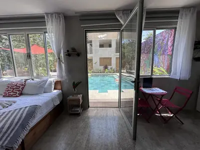 a bedroom with a bed and a swimming pool at Villa Alexandra in Punta Leona