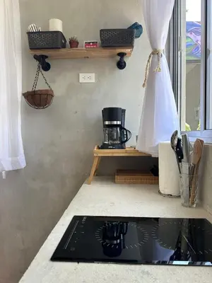 a kitchen counter top with a sink with a coffee maker at Villa Alexandra in Punta Leona