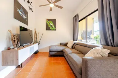 a living room with a couch and a tv at Casa Fe- Newly Renovated 2 bedroom condo in Ocotal