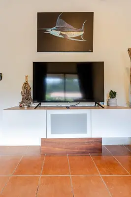 a flat screen tv sitting on top of a white cabinet at Casa Fe- Newly Renovated 2 bedroom condo in Ocotal