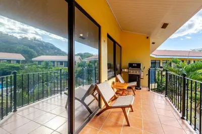 a balcony with two chairs and a desk on it at Casa Fe- Newly Renovated 2 bedroom condo in Ocotal