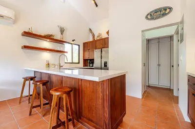 a kitchen with a wooden island with stools at Casa Fe- Newly Renovated 2 bedroom condo in Ocotal
