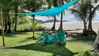 a group of blue chairs sitting on the beach at Down by the Sea, the beachfront Apartment & Studio in Puerto Coyote