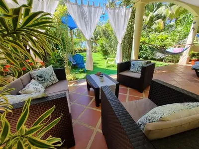 a patio with two couches and a table and chairs at Down by the Sea, the beachfront Apartment & Studio in Puerto Coyote