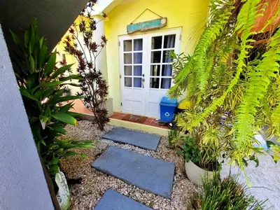 a front door of a yellow house with plants at Down by the Sea, the beachfront Apartment & Studio in Puerto Coyote