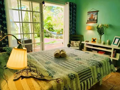 a bedroom with a bed with shoes on it at Down by the Sea, the beachfront Apartment & Studio in Puerto Coyote