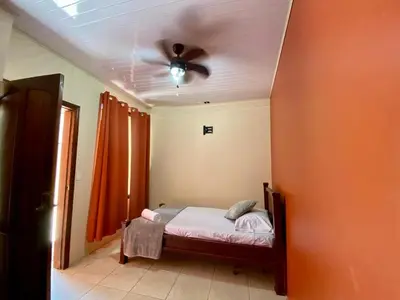 a bedroom with a bed and a ceiling fan at Casa Amura in Liberia