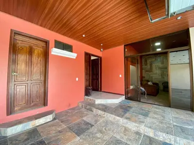 a house with a wooden door and a room at Casa Amura in Liberia