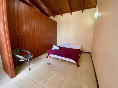 a small room with a bed and a chair at Casa Amura in Liberia