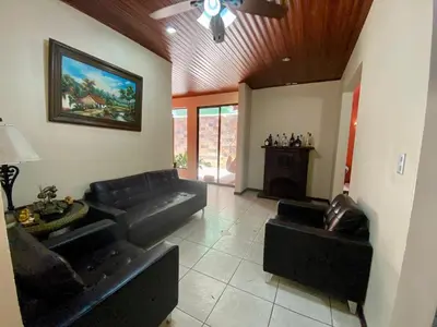 a living room with black leather furniture and a ceiling at Casa Amura in Liberia