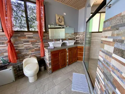 a bathroom with a toilet and two sinks in it at Casa Amura in Liberia