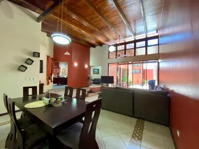 a dining room and living room with a table and chairs at Casa Amura in Liberia