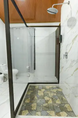 a shower with a glass door in a bathroom at A Frame Home in Cebadilla
