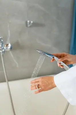 a person holding a pair of scissors in front of a shower at A Frame Home in Cebadilla