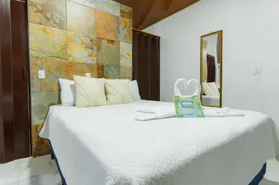 a bedroom with a large white bed with a mirror at A Frame Home in Cebadilla