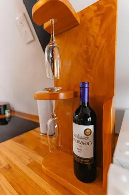 a bottle of wine sitting on a wooden table at A Frame Home in Cebadilla