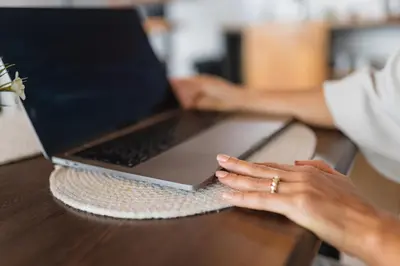 a woman sitting at a table with a laptop computer at A Frame Home in Cebadilla