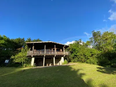 a house with a deck on top of a field at Vista de montaña in Barva