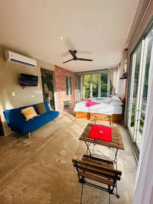 a bedroom with a bed and a blue couch at Villa Mary in Punta Leona