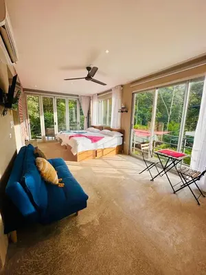 a living room with a bed and a blue couch at Villa Mary in Punta Leona