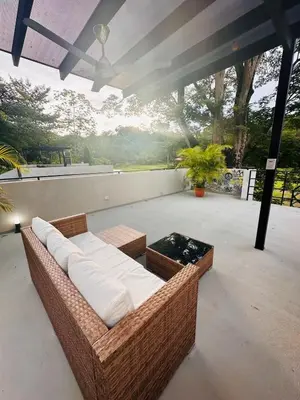 a large wicker couch sitting on a patio at Villa Mary in Punta Leona