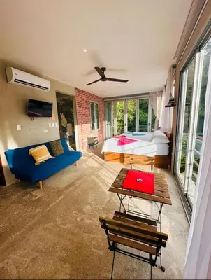 a bedroom with a bed and a blue couch at Villa Mary in Punta Leona