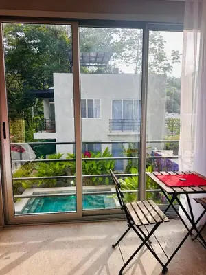 a room with a balcony with a table and a chair at Villa Mary in Punta Leona