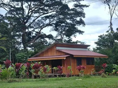 a small wooden house in a field with flowers at Sloth House in San Isidro