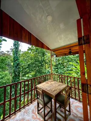 a porch with a table and chairs on a balcony at Sloth House in San Isidro