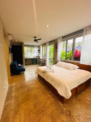 a bedroom with a large bed in a room with windows at Villa Carol in Punta Leona