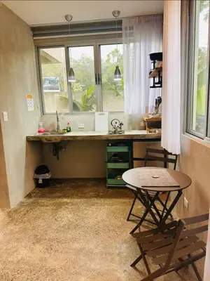 a kitchen with a table and a sink and a window at Villa Carol in Punta Leona