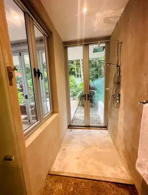 a bathroom with a window and a walk in shower at Villa Carol in Punta Leona