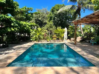 a swimming pool in front of a villa at Apartamentos El Labrador in Tamarindo