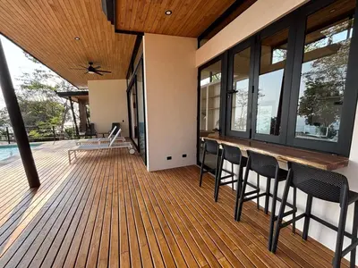 a deck with chairs and a bar on a house at Mar a Cielo Brand New Ocean View Retreat in Mal País