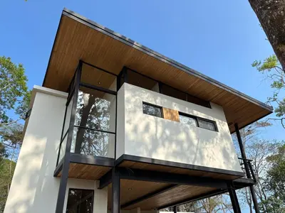 a modern house with a glass facade at Mar a Cielo Brand New Ocean View Retreat in Mal País
