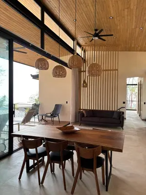 a dining room with a wooden table and chairs at Mar a Cielo Brand New Ocean View Retreat in Mal País