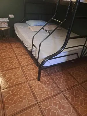 a bed in a room with a tiled floor at Sunset House Hostel in Liberia