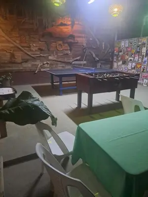a ping pong table and chairs in a room at Sunset House Hostel in Liberia