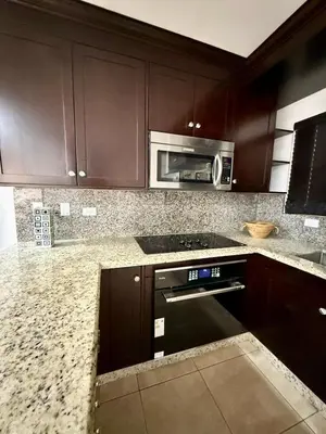 a kitchen with brown cabinets and a microwave at Relaxing 1BR Oasis near Tamarindo in Villarreal