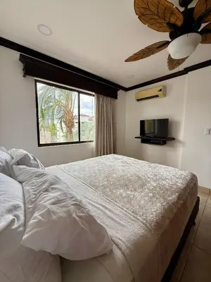 a bedroom with a bed with a ceiling fan and a window at Relaxing 1BR Oasis near Tamarindo in Villarreal