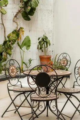 a table and chairs with plants on the wall at Habitación doble económica - Casa Esmeralda in San José