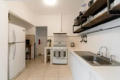 a kitchen with a sink and a stove at Habitación doble económica - Casa Esmeralda in San José