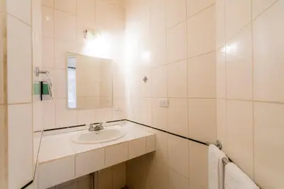a white bathroom with a sink and a mirror at Habitación doble económica - Casa Esmeralda in San José