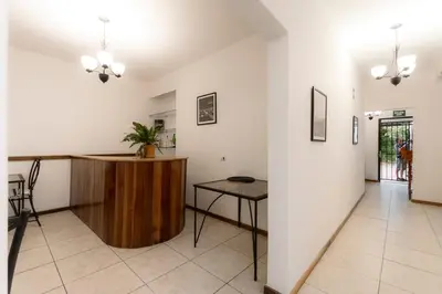 a living room with a table and a counter at Habitación triple confort - Casa Esmeralda in San José