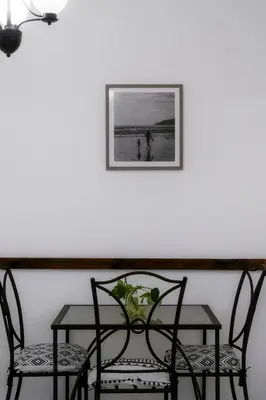 a table with two chairs and a picture on a wall at Habitación triple confort - Casa Esmeralda in San José
