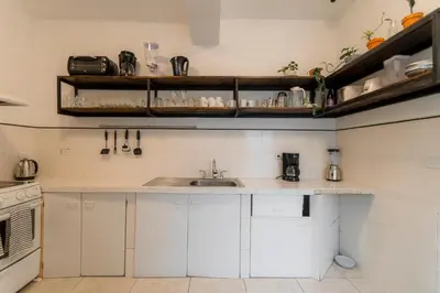 a kitchen with white cabinets and a sink at Habitación triple confort - Casa Esmeralda in San José