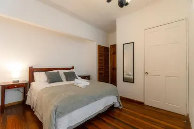 a bedroom with a large bed and a white door at Habitación doble delux - Casa Esmeralda in San José