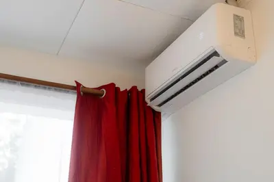 a room with a red curtain and a air conditioner at Habitación doble delux - Casa Esmeralda in San José